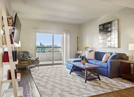 A living room with a blue couch and a grey rug.at 6940 Sepulveda, California, 91405