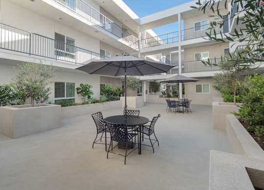 A patio with a table and chairs and an umbrella.at Grand View Towers, California, 90057