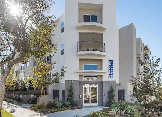 A modern building with a balcony on the second floor.at Grand View Towers, Los Angeles, CA  