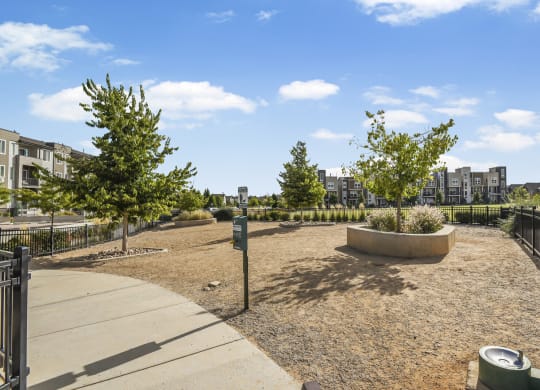 a park with trees and a fence and a city in the background at Parkside at Littleton Village, Colorado, 80122