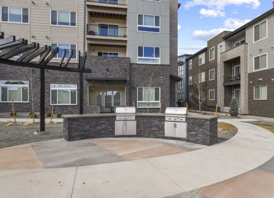 an outdoor kitchen with two stoves in front of an apartment building at Parkside at Littleton Village, Littleton, CO