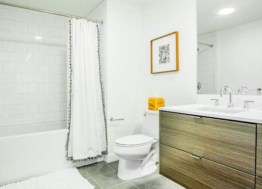 A bathroom with a toilet, sink, and shower.at The Rise, California, 94103