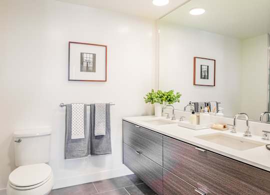 A bathroom with a toilet, sink, and mirror.at The Rise, San Francisco  
