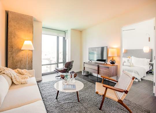 A living room with a white couch, a coffee table, and a chair.at The Rise, San Francisco, 94103  
