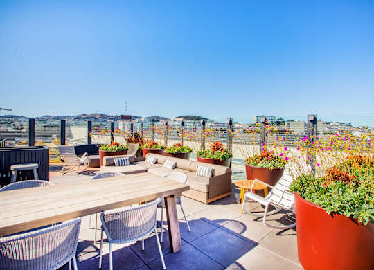 A patio with a table, chairs, and potted plants.at The Rise, San Francisco, CA  