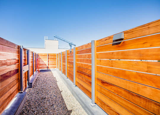 A wooden fence with a gravel path in the middle.at The Rise, San Francisco, CA  
