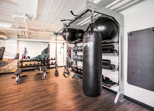 A gym with a punching bag hanging from the ceiling.at The Rise, California  