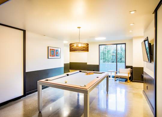 A pool table in a room with a television on the wall.at The Rise, San Francisco, CA  