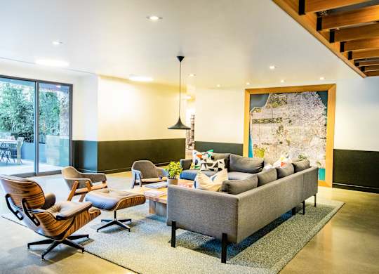 A living room with a grey couch and a wooden chair.at The Rise, San Francisco, 94103  