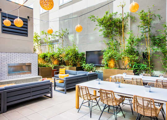 A modern outdoor dining area with a fireplace and seating for multiple people.at The Rise, California  