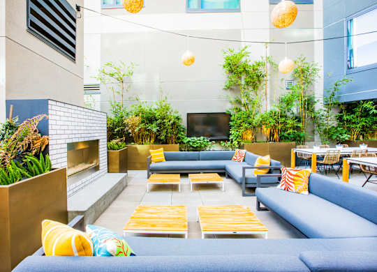 A modern outdoor seating area with blue couches and yellow cushions.at The Rise, San Francisco, CA 94103  
