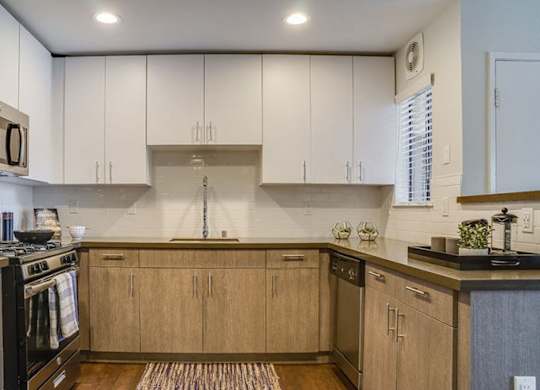 A kitchen with wooden cabinets and a black stove top oven.at Solterra At Civic Center, Norwalk, CA  