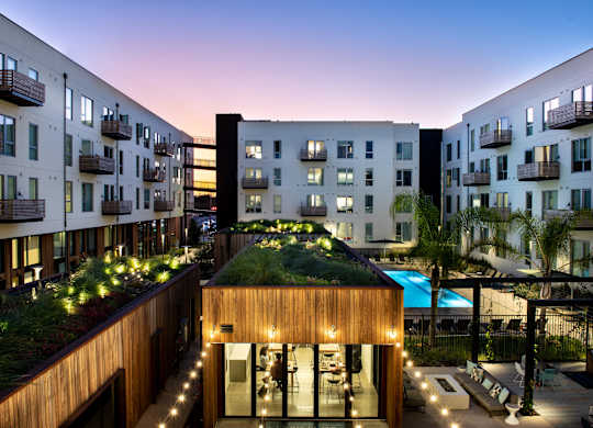 A modern building with a green roof and a pool.