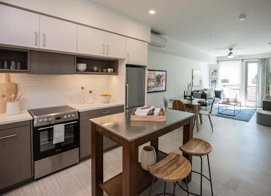 A modern kitchen with a wooden island and stools.