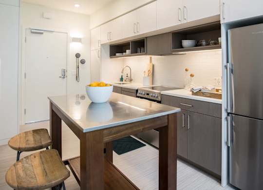 A modern kitchen with a wooden table and chairs.