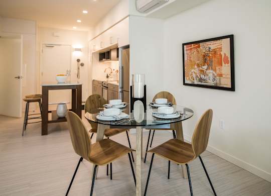A modern dining room with a glass table and chairs.