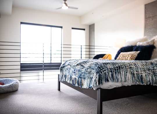 A bedroom with a bed, pillows, and a blanket.