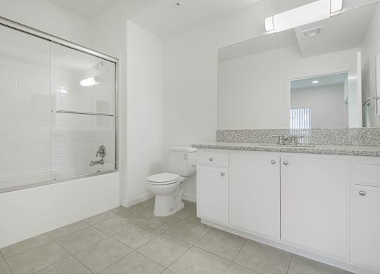 A white bathroom with a toilet, sink, and bathtub.