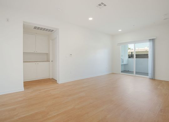 A large empty room with wooden floors and white walls.