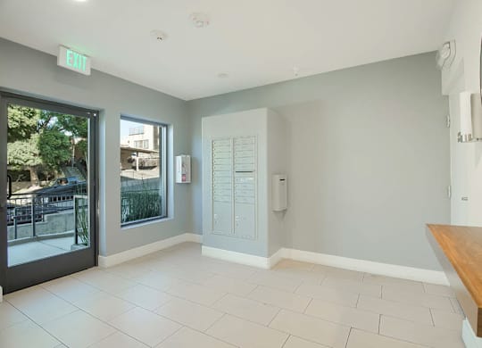 A room with a bench, a mirror, and a door with a window.
