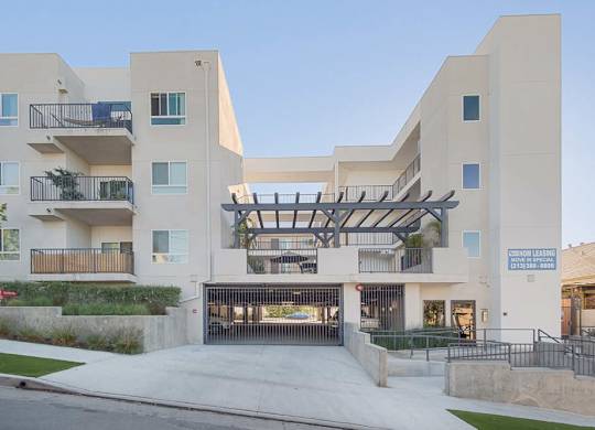 A modern building with a balcony and a sign that says
