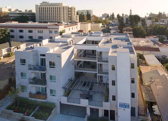 A modern apartment complex with a mix of white and grey buildings.