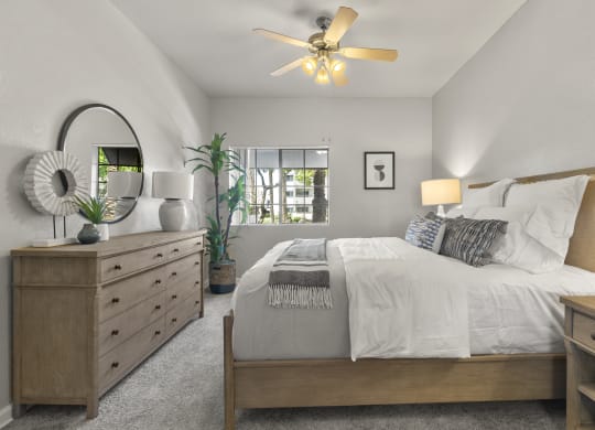 the master bedroom in a new home with a bed and dresser at Vaseo Apartments, Phoenix, AZ