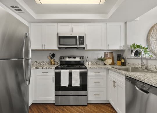 a kitchen with stainless steel appliances and white cabinets at Vaseo Apartments, Arizona, 85022