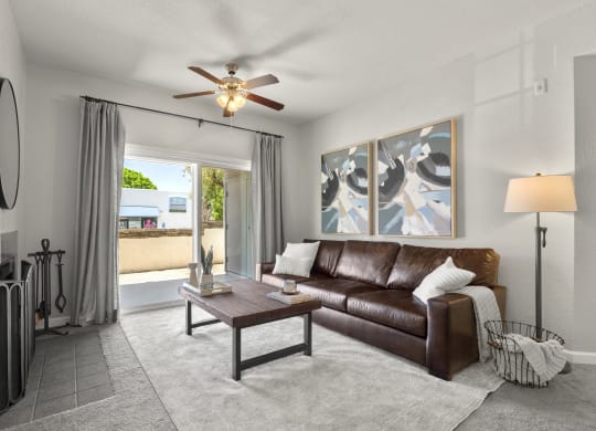 a living room with a couch and a ceiling fan at Vaseo Apartments, Phoenix