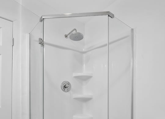 A white bathroom with a walk in shower at Verandas Apartments, West Covina, California