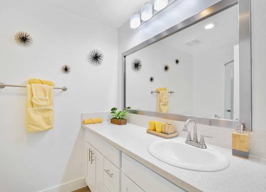 A bathroom with a white sink and a mirror at Verandas Apartments, West Covina