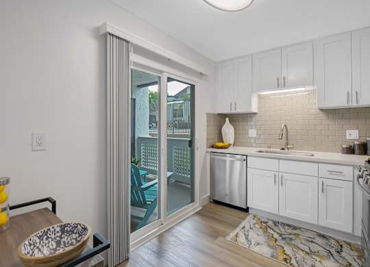 A kitchen with white cabinets and a marble floor at Verandas Apartments, California, 91791