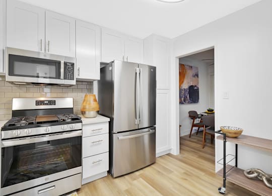 A kitchen with a stove, microwave, and refrigerator at Verandas Apartments, California, 91791