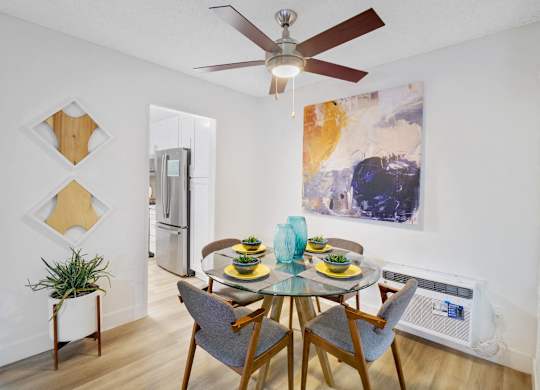 A dining room with a glass table and chairs at Verandas Apartments, West Covina
