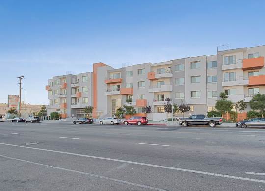 A street view of a residential area with cars parked and driving at Woodley Sara Apartment, California, 91406