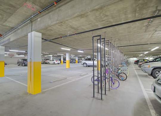 A parking garage with a yellow pole and bicycle rack at Woodley Sara Apartment, Van Nuys, CA, 91406