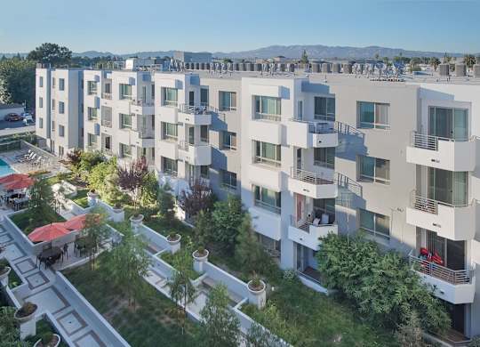 Apartment complex with white buildings and balconies at Woodley Sara Apartment, California