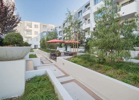 A white concrete pillar sits in the middle of a walkway at Woodley Sara Apartment, Van Nuys, CA, 91406