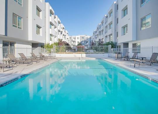 A swimming pool in front of apartment buildings at Woodley Sara Apartment, Van Nuys, CA, 91406