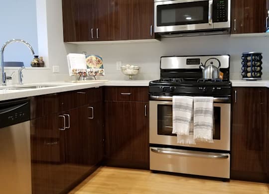 A modern kitchen with wooden cabinets and stainless steel appliances at Woodley Sara Apartment, California, 91406