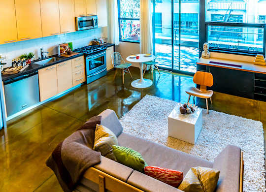 A modern kitchen with a refrigerator, microwave, oven, and sink.