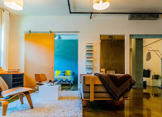 A room with a bed, a chair, and a table.