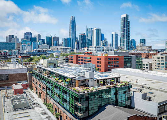 A cityscape with a mix of modern and older buildings, with a clear blue sky above.