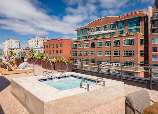 A small pool on a balcony with a sign that says "Caution: Capacity limited.".