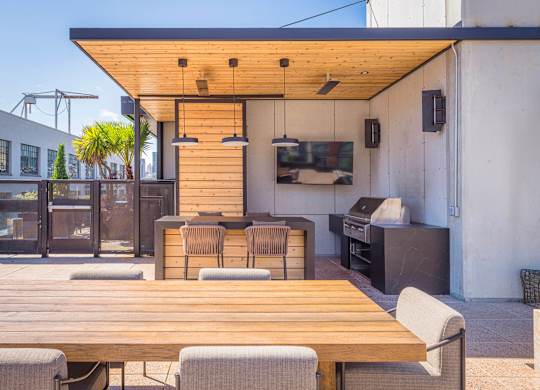 A wooden table is surrounded by chairs on a patio.