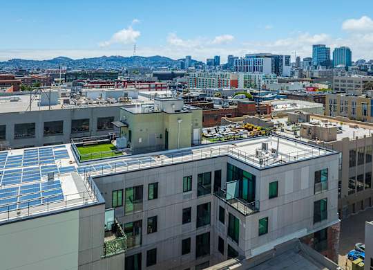 A cityscape with buildings and solar panels on the roofs.