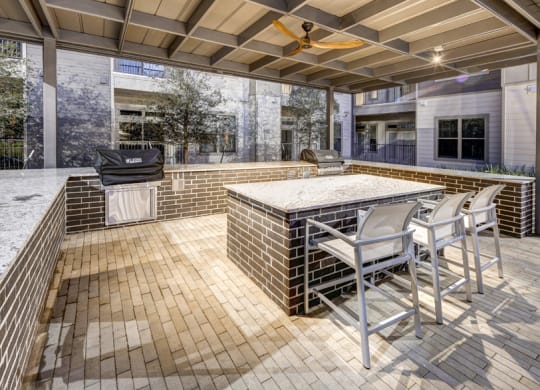 a patio with a bar and a grill at Arise Riverside, Austin, TX 