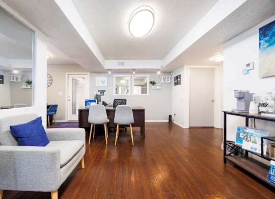 A living room with a grey couch and a wooden floor.