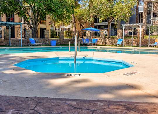 A round blue pool with a fountain in the middle.