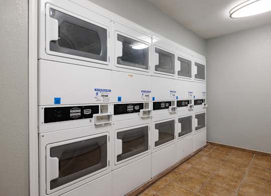 A row of white ovens are lined up in a room.